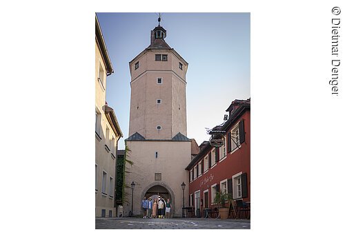 Bei einer Gästeführung schreiten Touristen durch den Torbogen des Blasturms