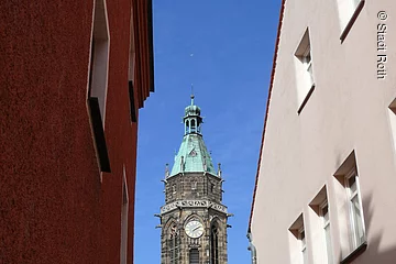 Sicht auf den Kirchturm der Evangelischen Stadtpfarrkirche in Roth. Der Turm enthält romantische Elemente.