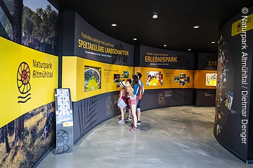 Eine Familie erforscht die Naturpark Altmühltal Ausstellung im Dinopark Denkendorf.