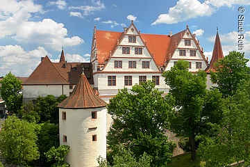 Panoramablick auf das Schloss Ratibor mit seinen Türmen und grünen Bäumen in Roth.