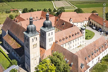 Das Kloster Plankstetten von oben mit der romanischen Kirche und den historischen Gebäuden, die sich vierseitig um den großen Kosterinnenhof stellen.