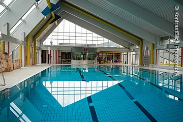 Innenansicht des Gredinger Hallenbads mit großen Fenstern und blauen Fliesen im Beckenboden