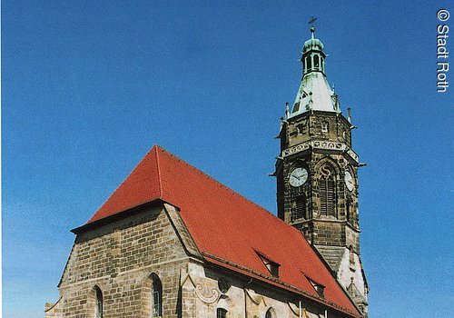 Rückansicht auf die Evangelische Stadtpfarrkirche in Roth mit dem Glockenturm mit romantischen Elementen.